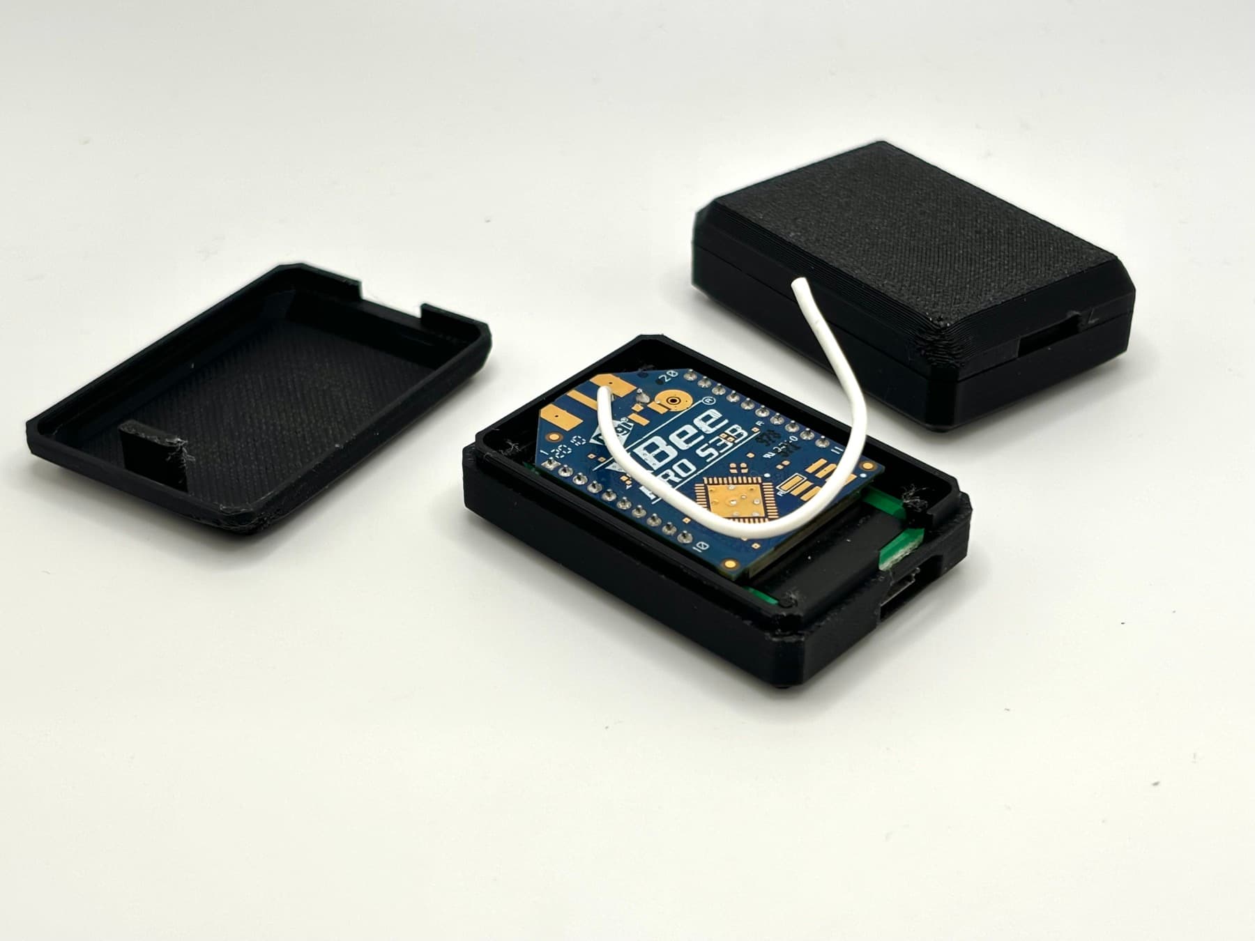Custom 3D printed two-piece black enclosure with a Bee Pro 539 PCB nested inside — a production electronics housing built by TAKT 3D
