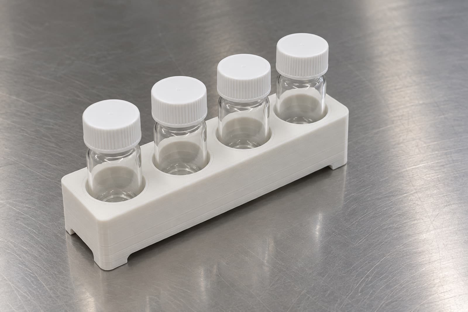3D printed four-position laboratory vial rack on a stainless steel bench