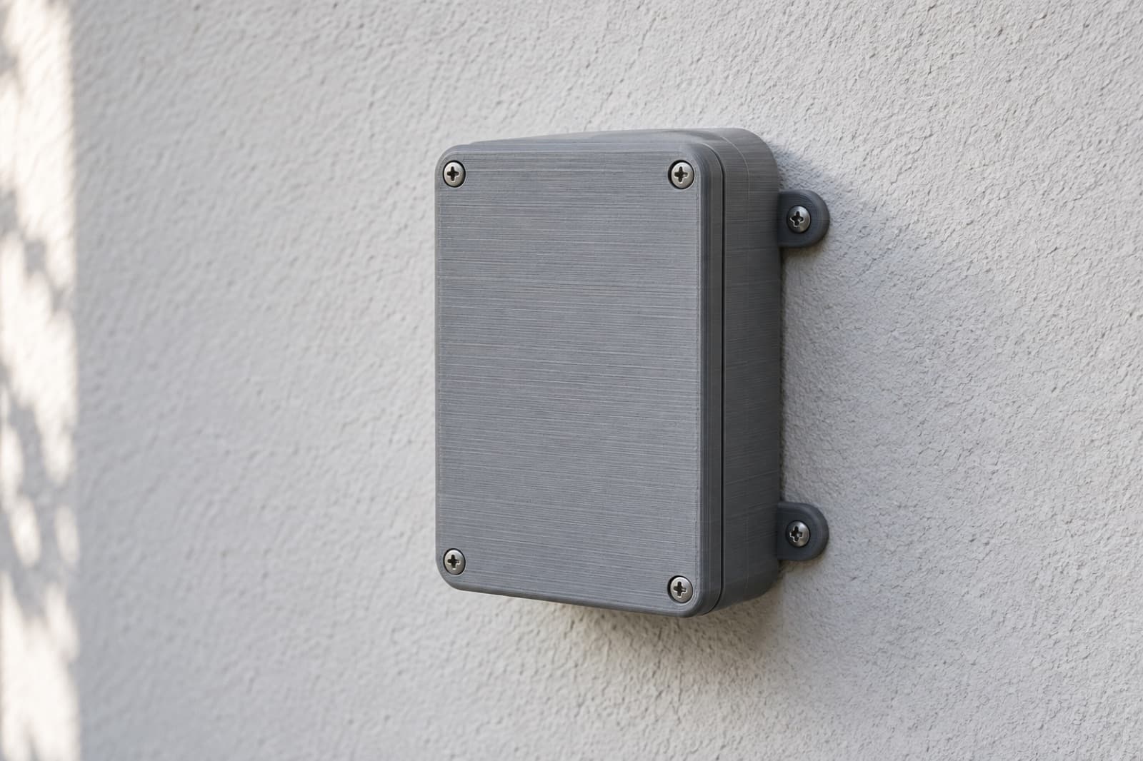 3D printed ASA enclosure mounted on an exterior stucco wall in direct sun, showing the UV and weather stability ASA is specified for