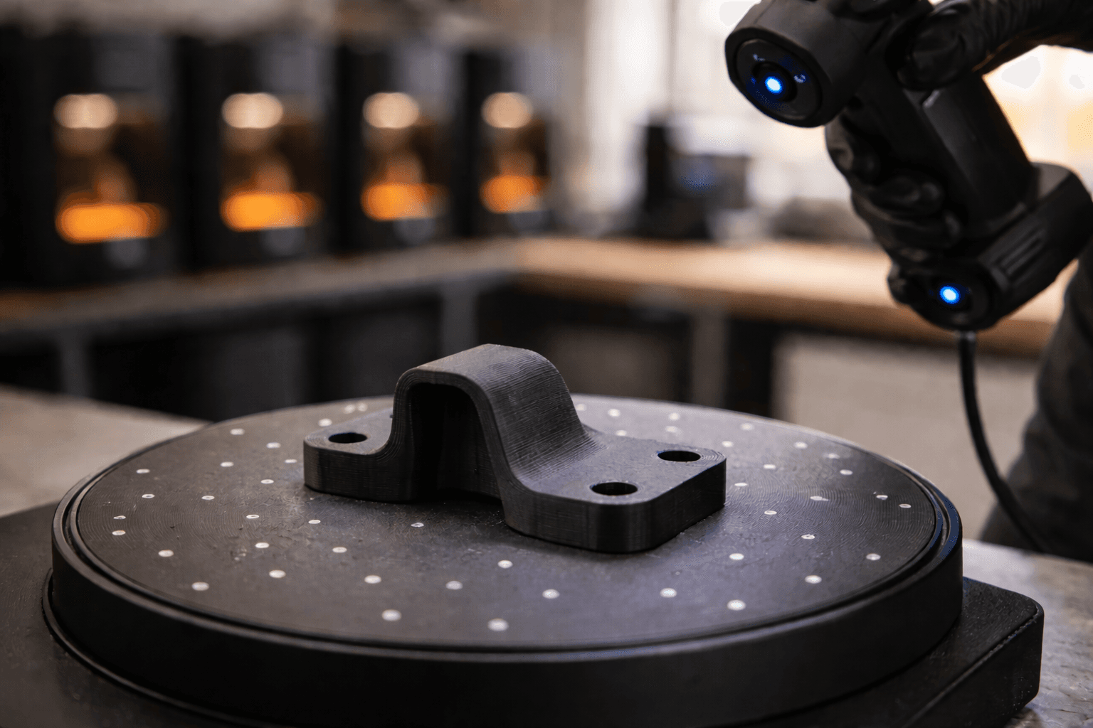 Black 3D printed bracket staged on a TAKT 3D scanning turntable with calibration targets, ready for a structured-light scan pass