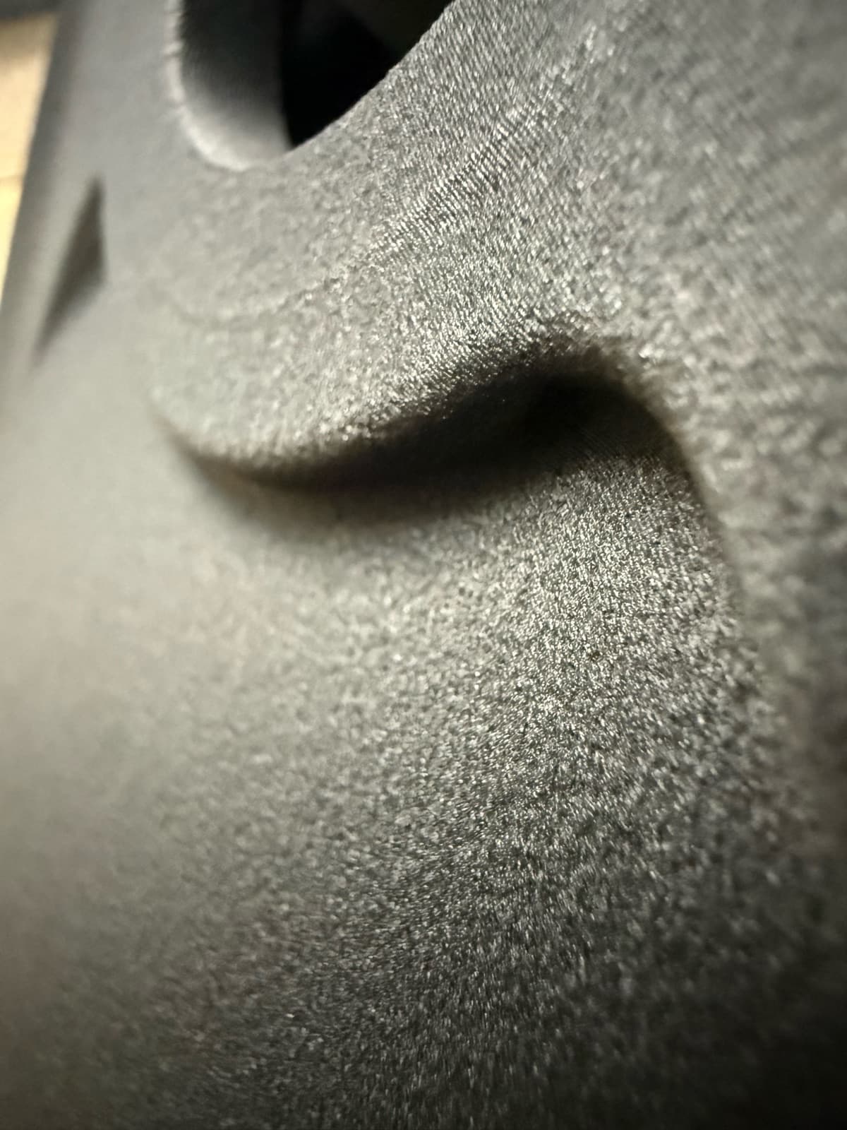 Macro photo of a carbon-fiber nylon 3D printed part showing the matte layer texture across a compound curve