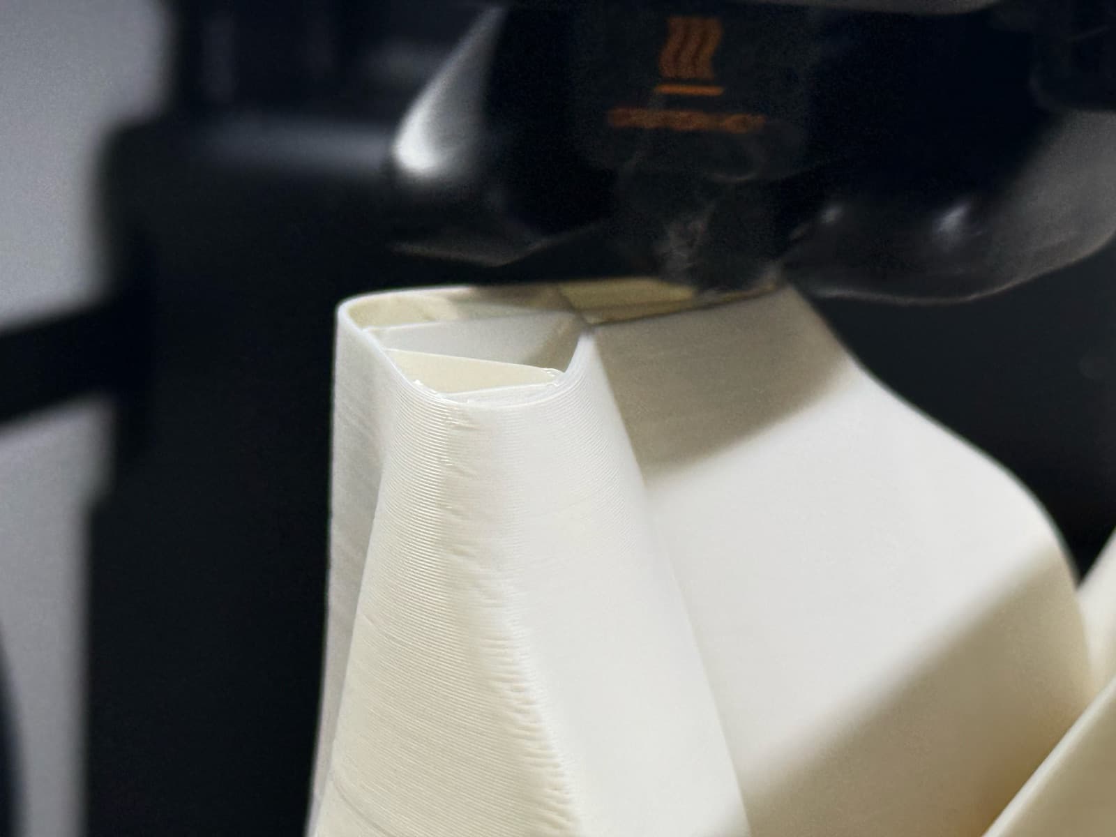 FDM print head laying down a white part mid-print at TAKT 3D